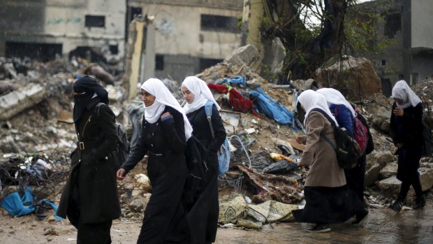 Palestinian schoolgirls walk past the rubble of a house in Gaza in recent days. 