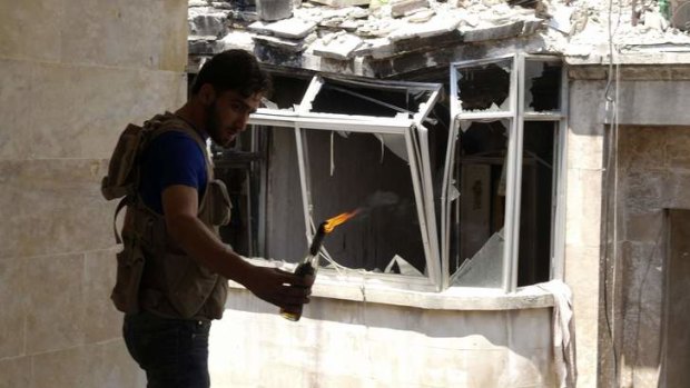 A Free Syrian Army fighter carries a Molotov cocktail to be thrown at forces loyal to Syria's President Bashar al-Assad in Aleppo's Salaheddine neighbourhood.