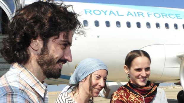 Released and relieved ... the three French aid workers are greeted as they arrive in Muscat.