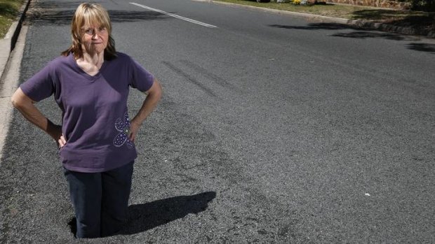 Renate Williams from Rivett standing in a hole that appeared in the road opposite her home, she sees it as a hazard to motorists and cyclists.
