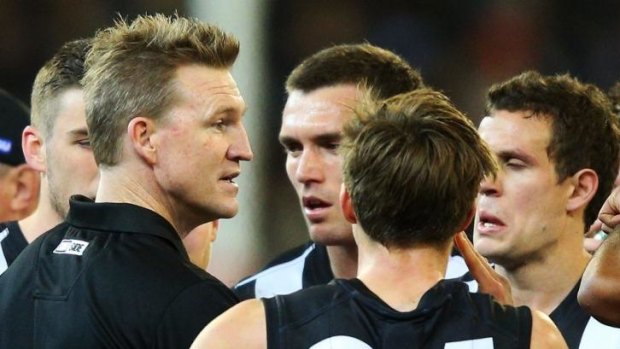Nathan Buckley and his players talk strategy during a break in the game.