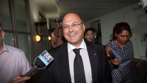 Senator Arthur Sinodinos is caught by reporters at Parliament House during Harmony Day.