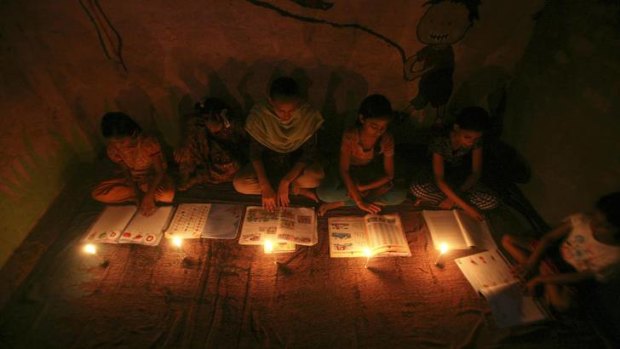 Blackout ... children study in the light of candles.