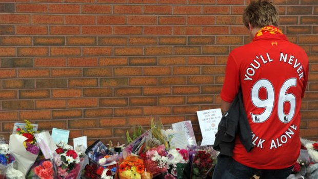 Remembering &#8230; a supporter pays respects to the victims after the inquest verdicts were overturned.