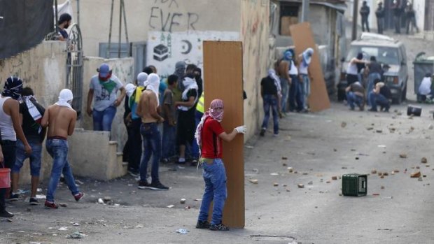 Protesters take cover in Jerusalem on Sunday.