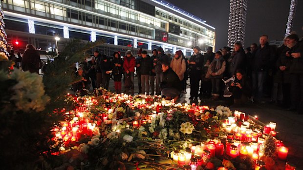 People lay flowers at a shrine near where 12 people died in the truck attack.