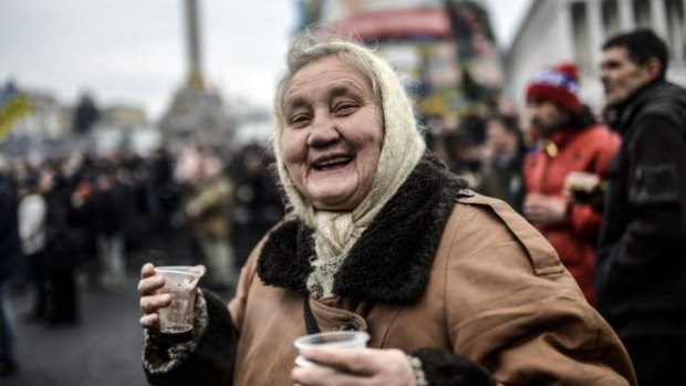 An old woman smiles while visiting Kiev's Independence square.