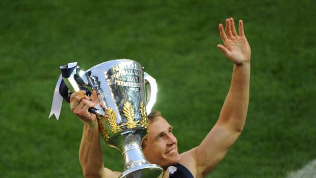 A job well done: Joel Selwood with the 2011 premiership trophy, the Cats' third in the AFL era.