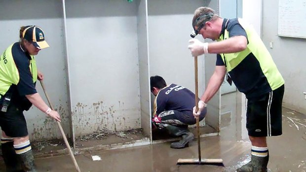 Workers begin the task of cleaning out the Suncorp Stadium change rooms.