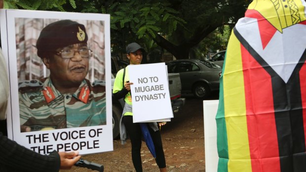 People hold their messages in Harare to demonstrate for the ouster of President Robert Mugabe.