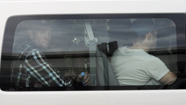 Port Adelaide players, including Matthew Broadbent, left, leave Adelaide airport after returning from their fateful Vegas trip.