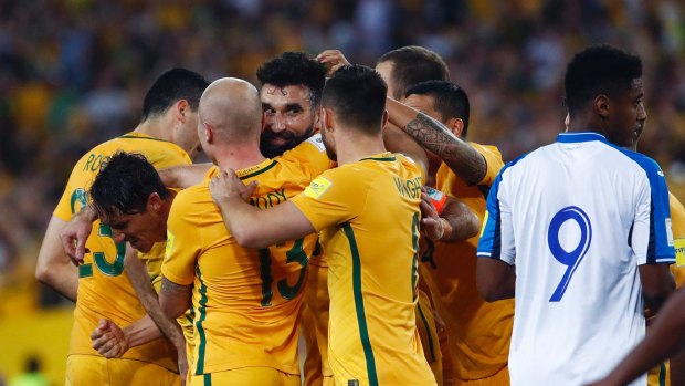 Job done: Mile Jedinak is mobbed after scoring.