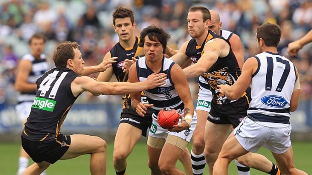 In trouble: Allen Christensen tries to get the ball to a Geelong teammate.