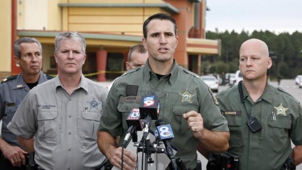 Pasco County Sheriff Chris Nocco (centre) speaks to the media as police tape surrounds the cinema in Wesley Chapel, Florida in the aftermath of the shooting.