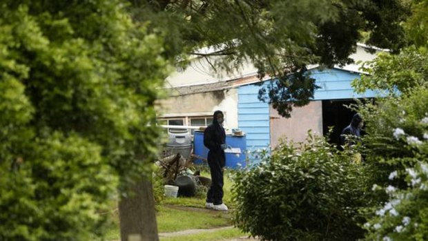 Police examine the shed where the woman's body was found.