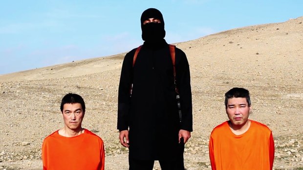 An Islamic State militant with Japanese hostages, journalist Kenji Goto, left, and military contractor Haruna Yukawa.