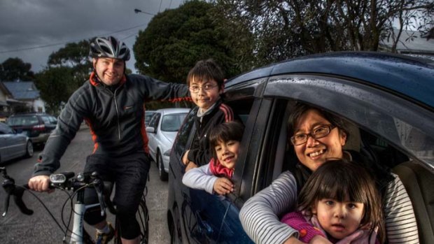 Damian Walsh cycles to work while Junko Kobayashi drives with their children (left to right) Declan, Grace and Gabbi.