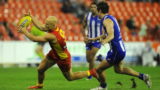 Gold Coast Suns' Gary Ablett collects the ball ahead of North Melbourne's Sam Wright.