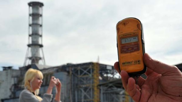 A guide holds a Geiger counter showing radiation levels 37 times higher than normal.