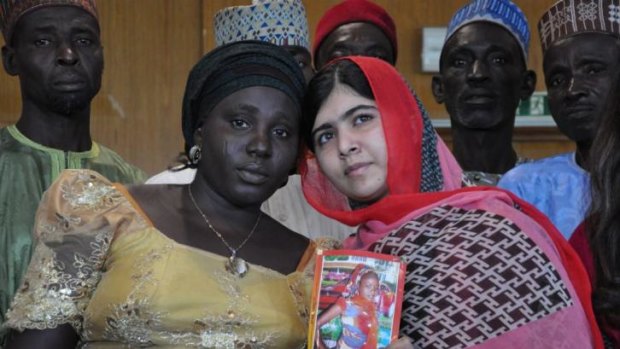 Pakistani activist Malala Yousafzai holds a picture of kidnapped schoolgirl Sarah Samuel with her mother Rebecca Samuel, during a visit to Abuja, Nigeria.