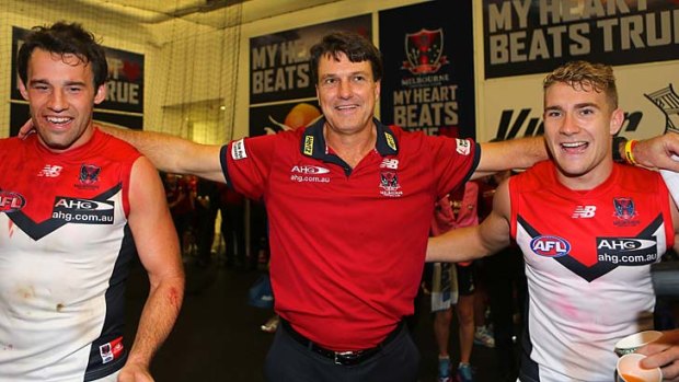Reason to rejoice: Paul Roos joins his players in singing the club song after Melbourne broke its duck for season 2014.