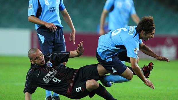 Tough tackle ... Sydney FC’s Hirofumi Moriyasu cops some rough treatment off Shanghai Shenhua’s Luis Angel Salmeron at the SFS last night.