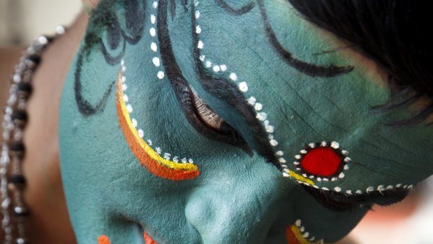 A Kathakali dancer prepares for a performance. The make-up session is one of the attractions of the event.