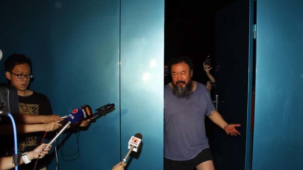 Considerably thinner ... Chinese artist Ai Weiwei waves from his studio after being released by Chinese police from prison, where he was kept for 81 days. Ai was detained at Beijing Airport on April 3.