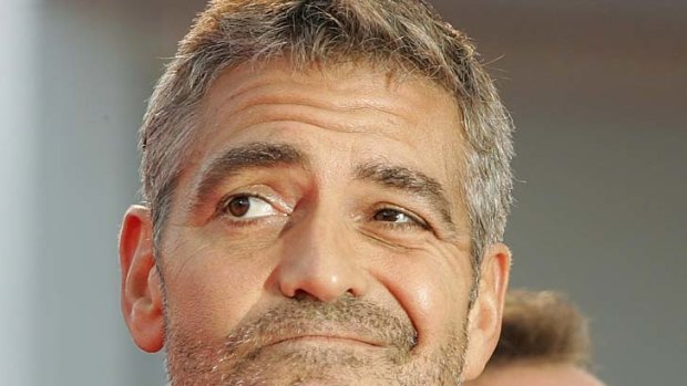 Actor George Clooney adjusts his bow tie.