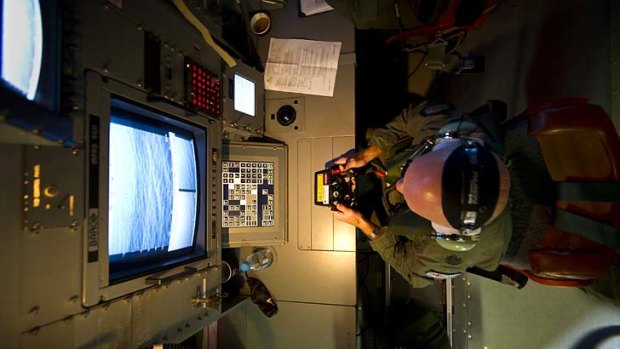 The hunt for debris: Warrant Officer Michael Wright uses scanners aboard an RAAF Orion aircraft.