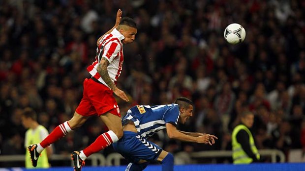 Jose Holebas of Olympiakos heads the ball over Sokratis Fytanidis of Atromitos during the cup final at the Olympic Stadium in Athens.