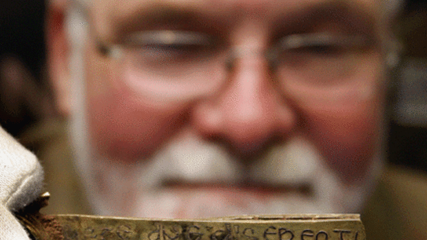 Kevin Leahy, from the Portable Antiquities Scheme, holds a strip of gold bearing a biblical inscription in Latin.