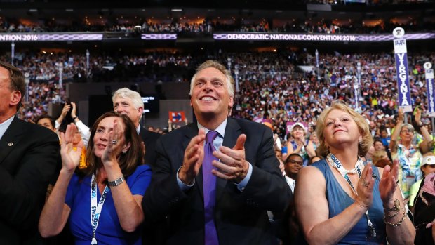 Virginia Governor Terry McAuliffe and other delegates applaud as Michael Bloomberg speaks at the Democratic National Convention last year. 