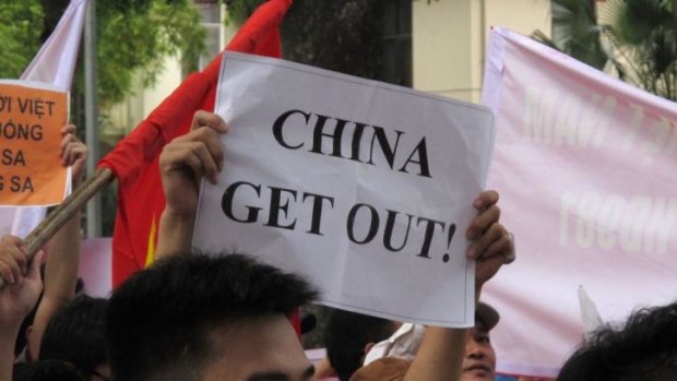 Vocal: A Vietnamese protester holds a banner in a rally against Beijing's deployment of an oil rig in the contested waters of the South China Sea, outside the Chinese Embassy in Hanoi.