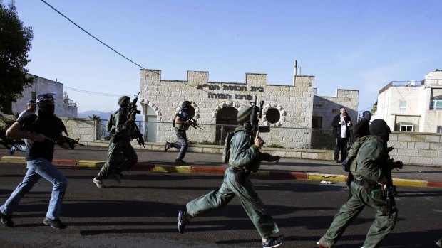 Israeli security personnel run next to the synagogue, where the attack took place.