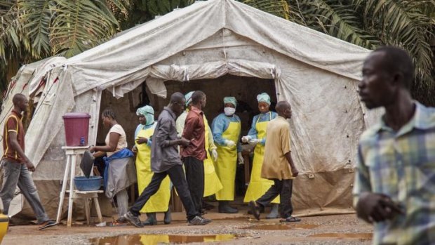Health workers screen people for Ebola at Kenema Government Hospital, Sierra Leone, on Saturday.