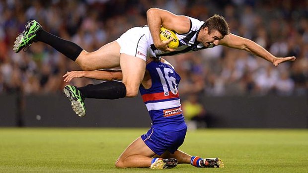 Big man in the game: Collingwood ruckman Darren Jolly is tackled by Western Bulldog Ryan Griffen.