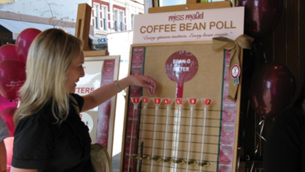 A woman casts her vote in the Miss Maud's coffee bean poll, which indicated a Liberal victory.