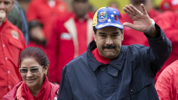 Venezuela's President Nicolas Maduro waves to supporters during a labor day march in Caracas. 