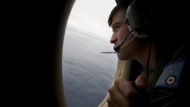 Still looking for the haystack ... A crewman of an RAAF AP-3C Orion aircraft looks out his observation window whilst searching for missing Malaysia Airlines Flight MH370 over the Indian Ocean.