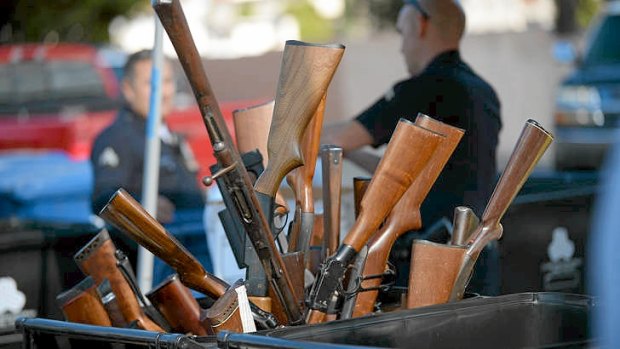 Rifles stick out of a bin during a gun buyback event in Los Angeles on Wednesday.
