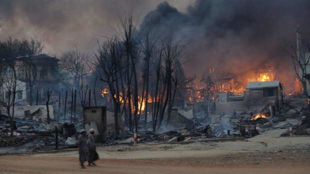 Residents walking past burning houses after riots in Meiktila, central Myanmar, last week.