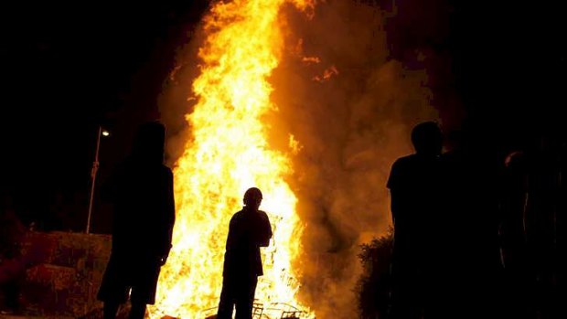 People are silhouetted against the flames from a bonfire in Killyleagh, Northern Ireland.