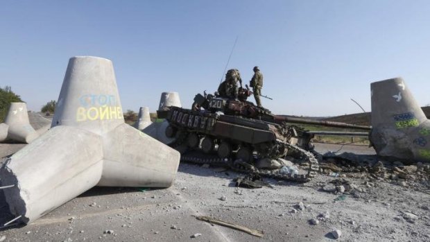 Ukrainian soldiers inspect a damaged tank on the outskirts of the southern coastal town of Mariupol over the weekend.