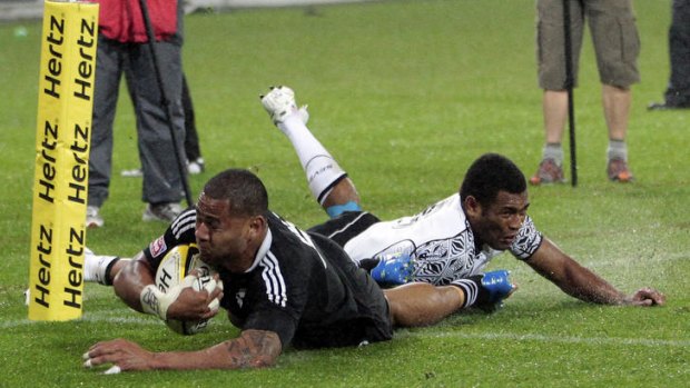 Frank Halai of New Zealand scores in the final despite being tackled by Metuisela Talebula of Fiji.