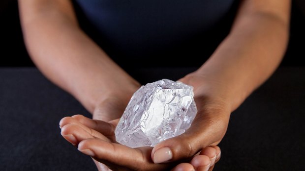 A Sotheby's employee in New York holds the Lesedi La Rona - the largest diamond discovered in more than a century.