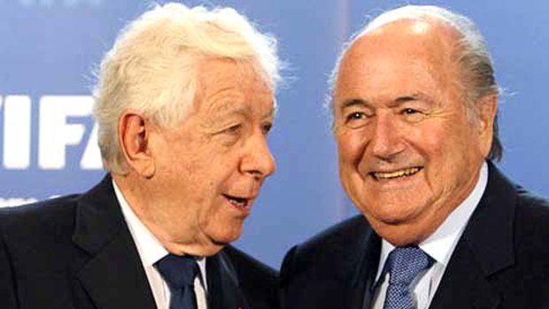 Australia's FFA Chairman Frank Lowy (L) submits his country's official bid book for the 2018 or 2022 Soccer World Cup to FIFA President Sepp Blatter.