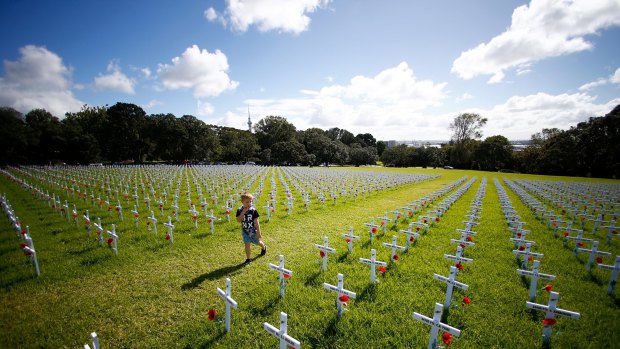 Children walk through a field of memorial crosses on the lawn in front of the Auckland War Memorial Museum in Auckland, New Zealand. The field of white crosses has been installed in the lead up to ANZAC Day. 