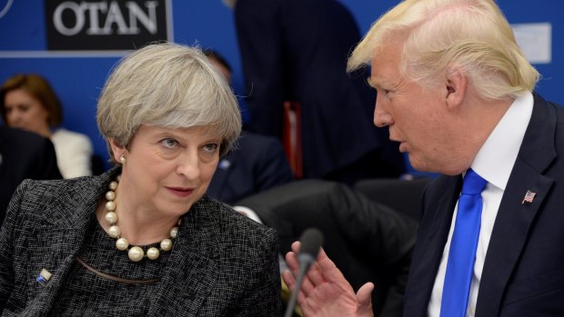 British PM Theresa May listens to US President Donald Trump at a NATO dinner in Brussels on Thursday.