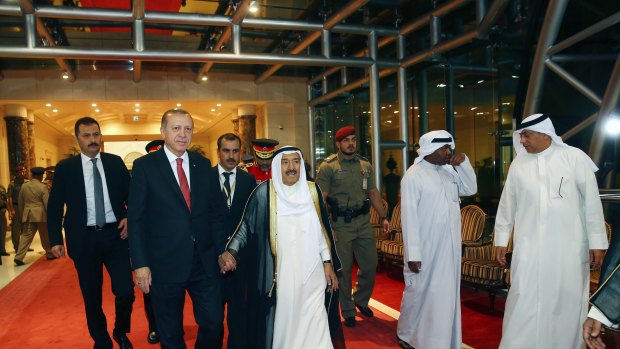 Turkish President Recep Tayyip Erdogan, second left, walks with the Emir of Kuwait Sheikh Sabah al-Ahmad al-Sabah, center, prior to their meeting in Kuwait City on Sunday.